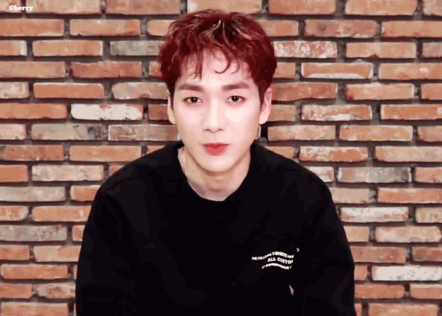 a young man with red hair is wearing a black shirt that says " the first all custom " on the back