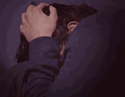 a close up of a man 's face with his hand on his face