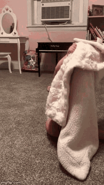 a child is hiding under a white blanket in a room with a kelly keag piano in the background