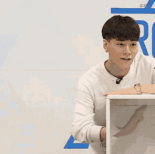a young man is sitting at a table with a microphone in his mouth .