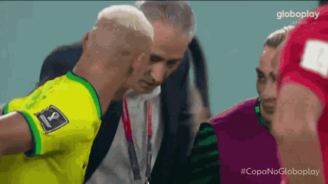 a man in a yellow shirt with the number 8 on it talks to another man