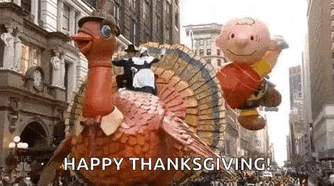 a parade with a turkey , peanuts balloons , and a scarecrow .
