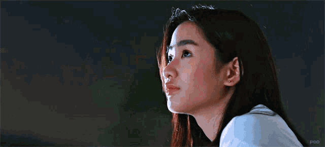 a close up of a woman 's face in a dark room