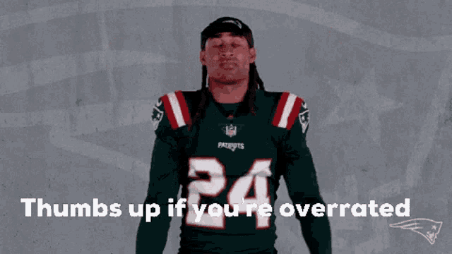 a man wearing a patriots jersey is giving a thumbs up