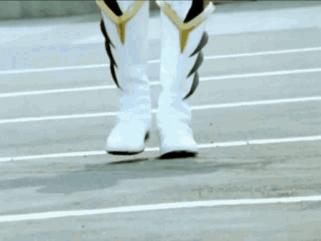 a person wearing a pair of white boots is walking on a track
