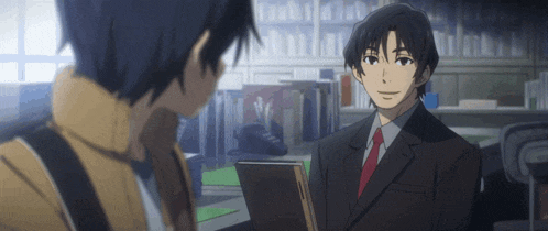 a man in a suit and tie talking to another man in a library