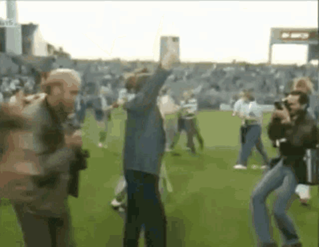 a blurry picture of a group of people dancing on a field