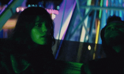 a woman with a green face is sitting in a car with a man behind her