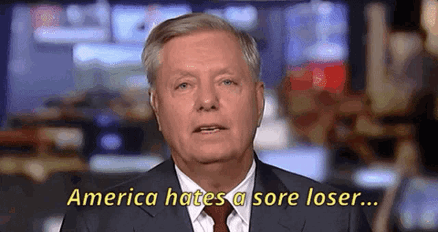 a man in a suit and tie is saying america hates a sore loser .