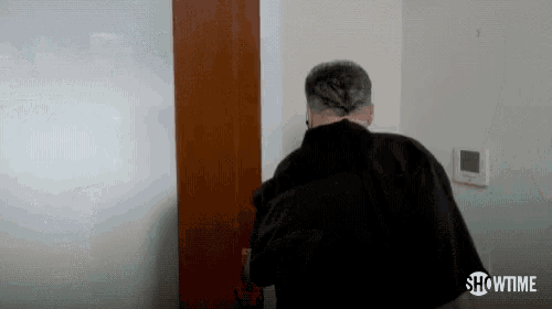 a man is standing in front of a door with a showtime logo on the bottom .