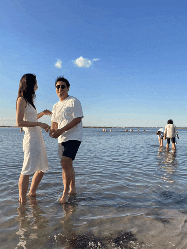 a man and a woman are standing in a body of water