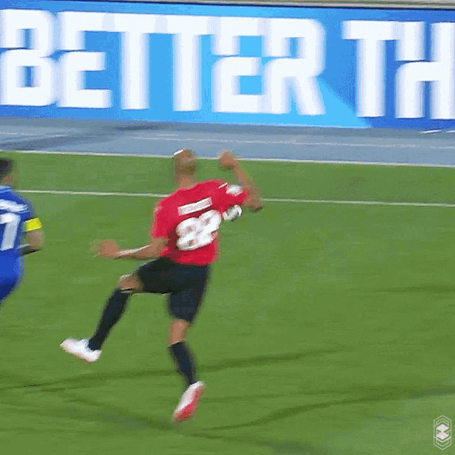 a soccer player in a red shirt with the number 28 jumps in the air