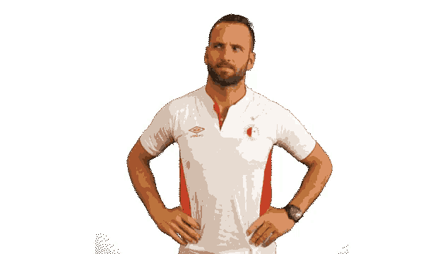 a man with his hands on his hips wearing a white shirt with umbro on it