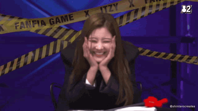 a woman is sitting in front of a tape that says fanfia game