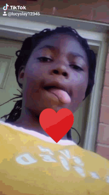 a girl with her tongue out and a heart in her mouth is a tiktok video