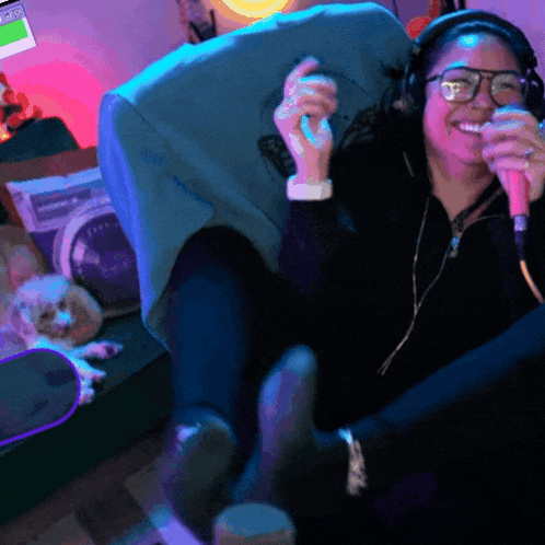 a woman singing into a microphone while wearing headphones and glasses