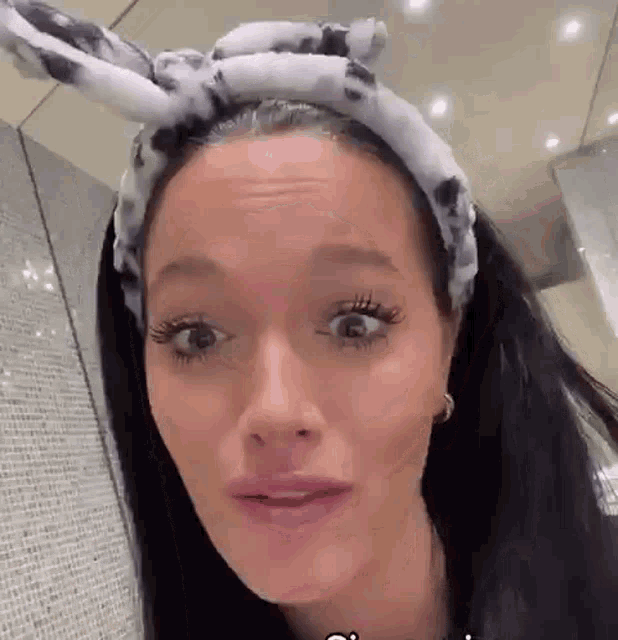 a woman wearing a headband with bunny ears on her head .