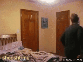 a man is standing in a bedroom with the website shooshtime.com on the bottom right