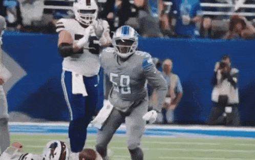 a football player in a number 50 jersey is running on the field during a game .
