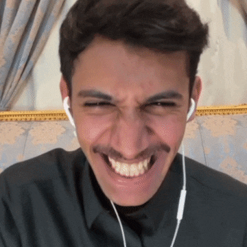 a man with a mustache wearing ear buds makes a funny face