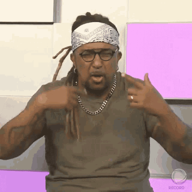 a man with dreadlocks and a bandana on his head is making a funny face