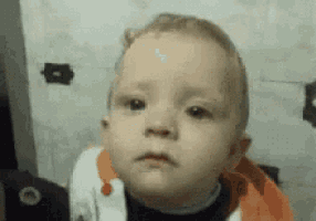 a close up of a baby making a funny face
