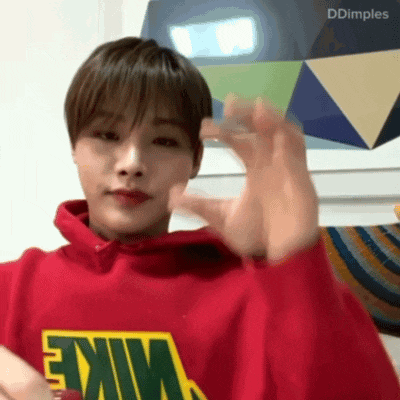 a man wearing a red nike sweatshirt waves