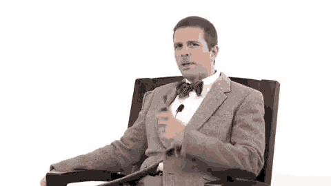 a man is sitting in a chair with a pipe in his mouth .