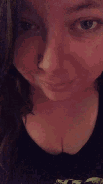 a close up of a woman 's face with a nose ring on it .