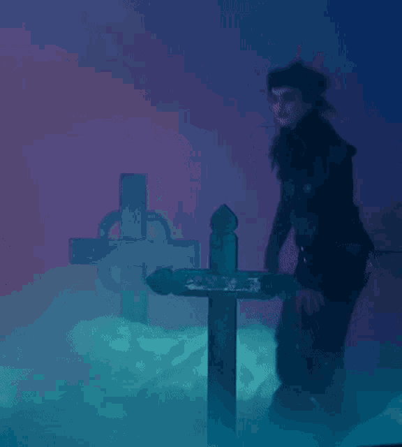 a person standing next to a cross in a cemetery