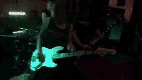 a man playing drums and a woman playing a bass guitar