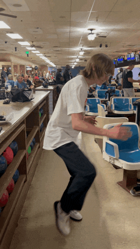 a man in a white shirt is playing bowling