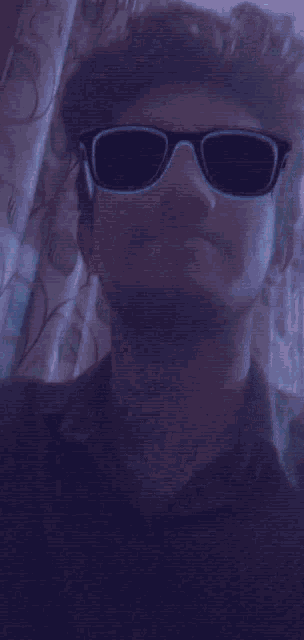 a man wearing neon sunglasses with the name angana thanne below him