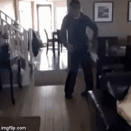 a man in a black shirt is dancing in a living room