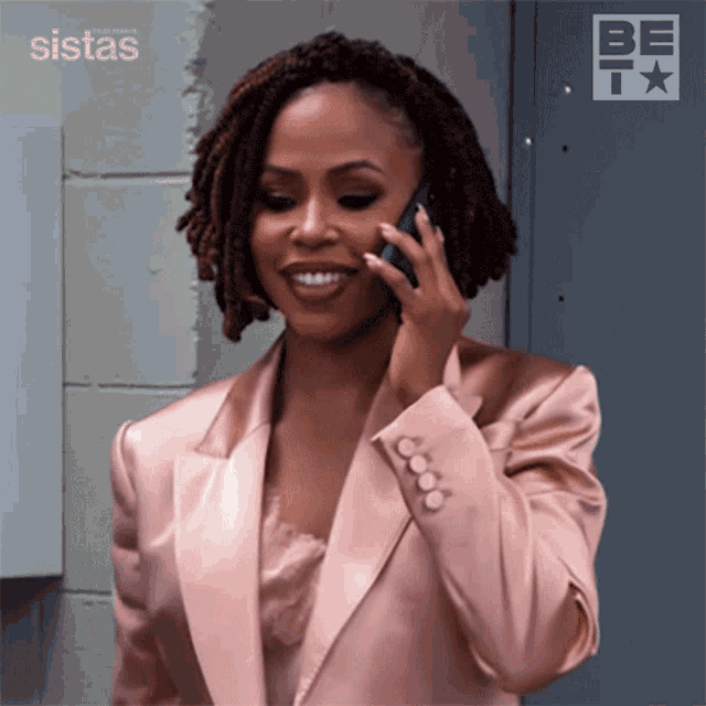 a woman in a pink suit is talking on her phone