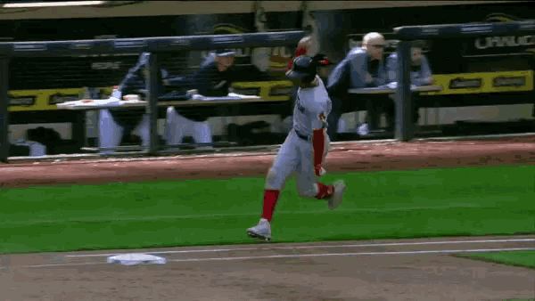 a baseball player is running on the field with a dugout in the background that says corona