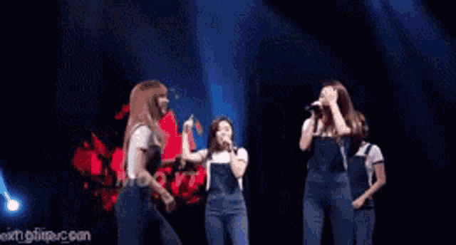 a group of girls are singing into microphones on a stage with imgflip.com in the corner