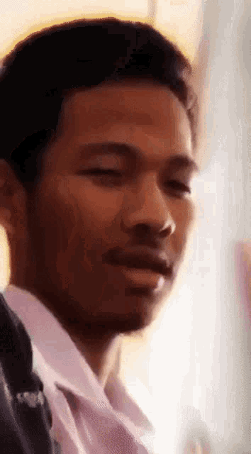 a close up of a man 's face with his eyes closed and his mouth open