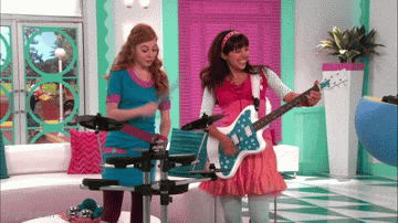 a girl playing a guitar and another girl playing a drum set