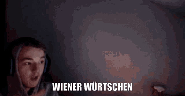 a person wearing headphones says wiener wurtschen in front of a dark background