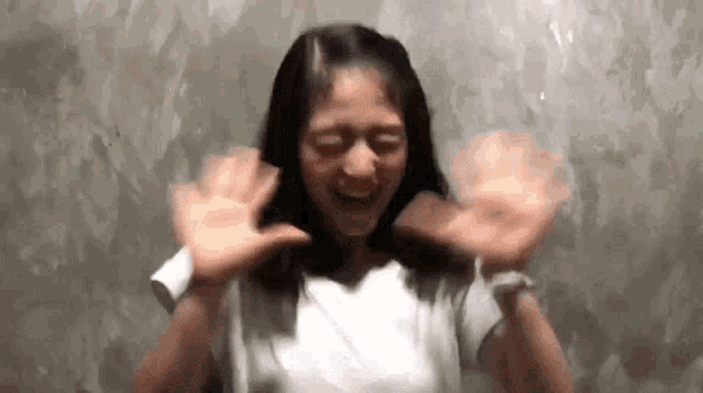 a woman is making a funny face with her hands outstretched .