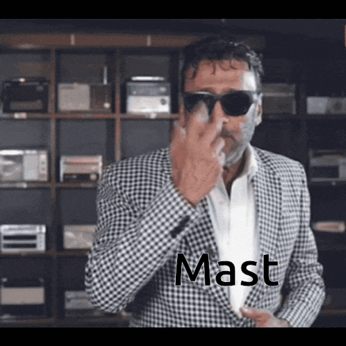 a man wearing sunglasses and a suit has the word mast written on his jacket
