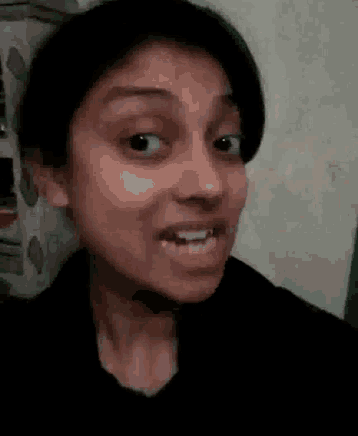 a close up of a woman 's face making a funny face with her mouth open .