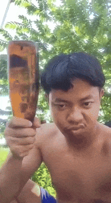 a shirtless boy is holding a glass of beer