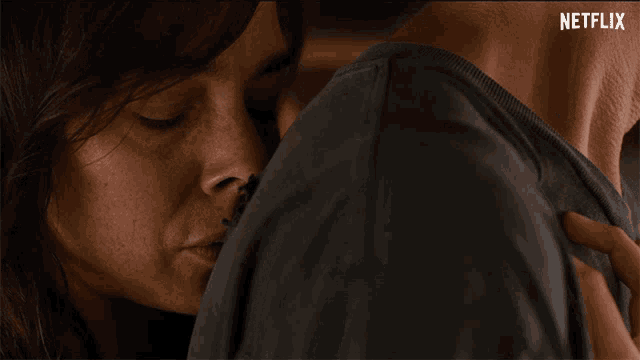 a close up of a woman kissing a man 's neck with netflix written on the bottom