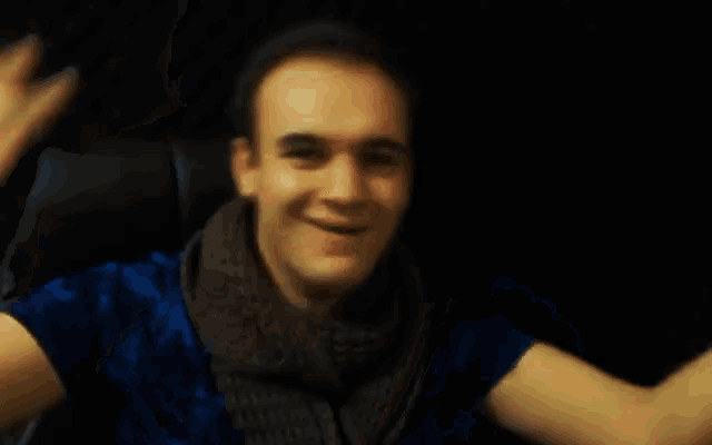 a blurry picture of a man in a blue shirt and scarf