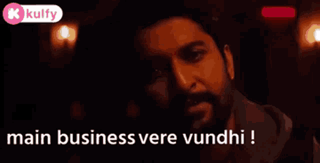 a man with a beard is looking at the camera and says main business vere vundhi !