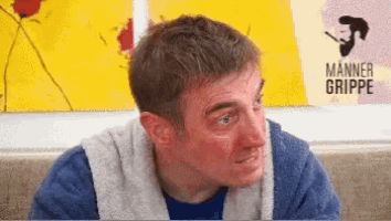 a man with a towel around his neck is sitting in front of a manner grippe poster