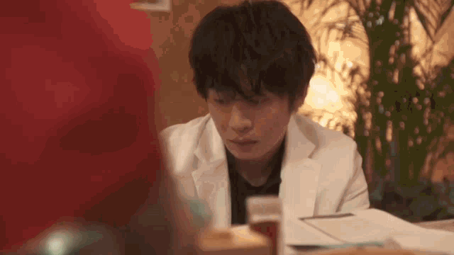 a man in a white coat is sitting at a table