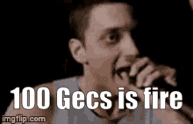 a man is singing into a microphone with the words 100 gecs is fire behind him .